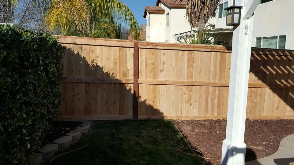 Wood picture frame fence and gate facing a neighborhood street